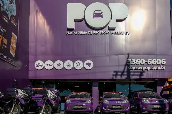 Fachada da matriz da POP em Contagem, com a frota adesivada de roxo na frente da loja