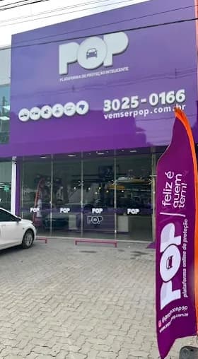 Entrada da loja com o wind banner da POP na calçada